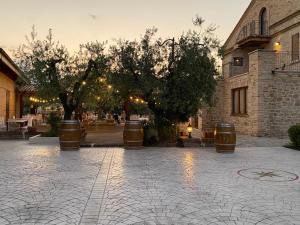 un patio con barriles y árboles y un edificio en Agriturismo Oasi Biologica, en Montedinove