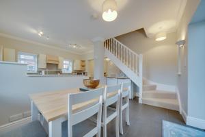 a kitchen and dining room with a table and stairs at Super 5 Bedroom Family Friendly Retreat Rustington in Littlehampton