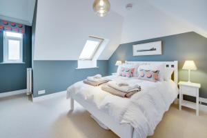 a bedroom with a large white bed with blue walls at Super 5 Bedroom Family Friendly Retreat Rustington in Littlehampton