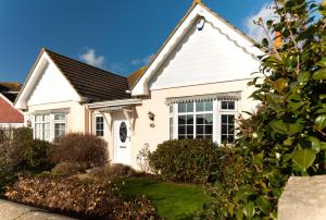 une maison blanche avec un toit noir dans l'établissement Super 5 Bedroom Family Friendly Retreat Rustington, à Littlehampton
