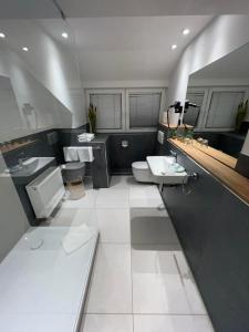 a bathroom with two sinks and a toilet and a sink at Hotel-Restaurant Amadeus in Hannover