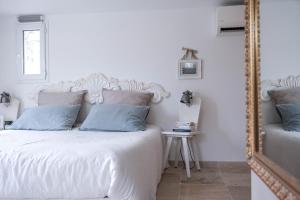 a bedroom with a white bed and a mirror at Chambres d'hôtes Villa Cardabella in Le Tignet