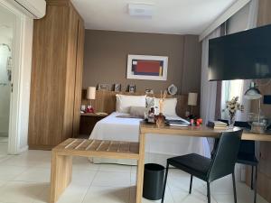 a bedroom with a bed and a desk with a desk at RIO STAY RESIDENCE in Rio de Janeiro