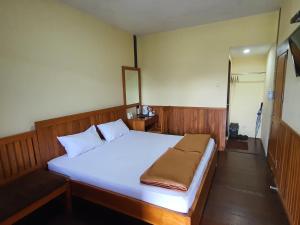 sypialnia z dużym łóżkiem z białą pościelą w obiekcie Nusantara Hotel Sembalun w mieście Sembalun Lawang