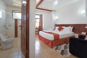 ein Schlafzimmer mit einem Bett und ein Badezimmer mit einer Toilette in der Unterkunft The Kyaka Hotel in Machakos