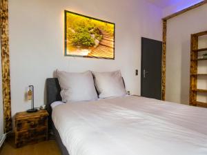 um quarto com uma cama branca e uma fotografia na parede em #111 - LUX-Flat Lennep - Altstadt - Netflix & Amazon Prime - Felswand em Remscheid