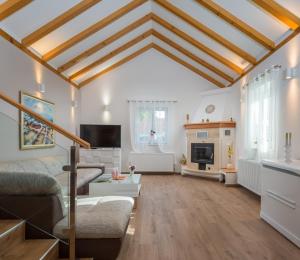 a living room with white walls and wooden ceilings at Villa Giardino in Drinovci
