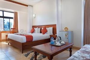 ein Hotelzimmer mit 2 Betten und einem Couchtisch in der Unterkunft The Kyaka Hotel in Machakos