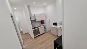 a small kitchen with white appliances and wooden floors at Sublime in Bari