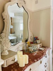 a bathroom with a large mirror on a dresser at The Willowford in Milton Keynes