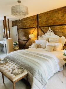 a bedroom with a large white bed with a wooden wall at The Willowford in Milton Keynes