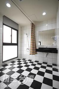ein Bad mit schwarz-weiß kariertem Boden in der Unterkunft CoCo Motel Boutique in Puli