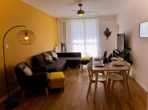 a living room with a couch and a table at Rives Occitanes, Appartement Toulouse Purpan in Toulouse