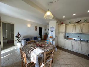 a living room with a table and a kitchen at Casa Bianca in Pietrasanta +11 photos