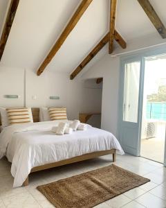 a white bedroom with a large bed and a window at King A in Argostoli