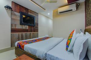 1 dormitorio con 1 cama y TV en la pared en FabHotel Middleton Desire, en Bhubaneshwar