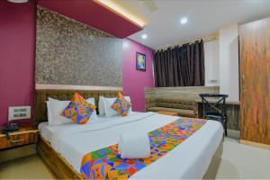 1 dormitorio con 1 cama grande y paredes moradas en FabHotel Middleton Desire, en Bhubaneshwar