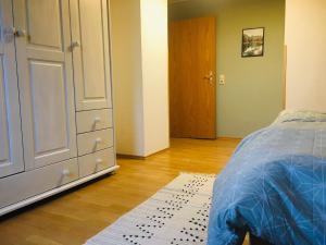 a bedroom with a bed and a dresser and a door at Ferienwohnung Brehm in Bad Staffelstein