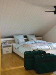 a bedroom with a bed and two luggage bags at Ferienwohnung Brehm in Bad Staffelstein