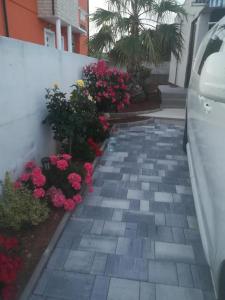 a walkway with pink flowers next to a building at Kuća za odmor MARIA in Vodice +46 photos