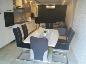 a dining room and kitchen with a white table and chairs at Kuća za odmor MARIA in Vodice