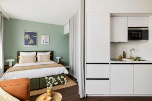 a bedroom with a bed and a kitchen at COVE Centrum in The Hague