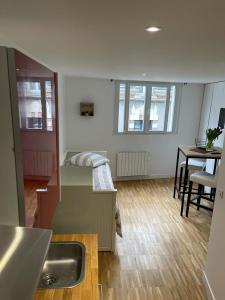a room with a bed and a kitchen with a table at Les 3 rois in Romorantin