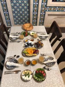 a table with plates of food on it at Shohnishin Boutique in Bukhara