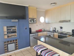 a kitchen with a blue island in the middle at Santos 49 in Mossel Bay +11 photos