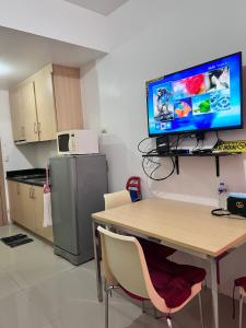 a kitchen with a table and a television on a wall at Studio Units at SM Light Residences Condo Beside Boni MRT Station in Manila