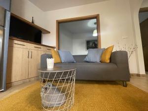 ein Wohnzimmer mit einem grauen Sofa mit gelben und blauen Kissen in der Unterkunft Grupo Gontad Apartamento Travesía da Agra in A Coruña