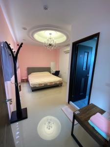 een kamer met een bed, een tafel en een spiegel bij 葳葳民宿 in Magong