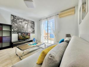 - un salon avec un canapé et une télévision dans l'établissement Playa Arena Apartment, à Araya