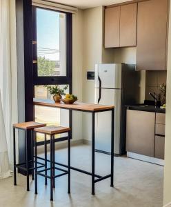 a kitchen with a table and two stools and a refrigerator at LA ESQUINA MONOAMBIENTE in Reconquista +7 photos