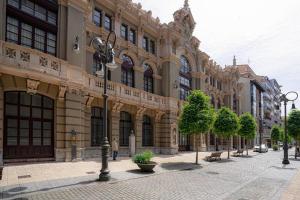 una strada di fronte a un grande edificio di Apartamento Palacio Valdés, centro Avilés, con parking ad Avilés