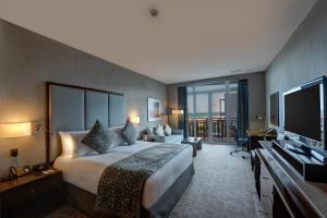 a hotel room with a large bed and a flat screen tv at Crowne Plaza Duqm, an IHG Hotel in Duqm