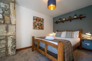 a bedroom with a bed and a stone wall at Woodbottom Farm - A Splendid Yorkshire Getaway in Todmorden