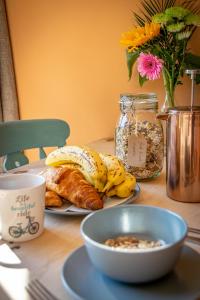 a table with a plate of food and a bowl of bread at Woodbottom Farm - A Splendid Yorkshire Getaway in Todmorden