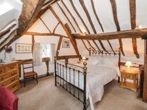 a bedroom with a bed and a desk at Apple Tree Cottage in Evesham