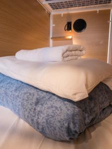 a bed with towels sitting on top of it at Smart Camden Inn Hostel in London