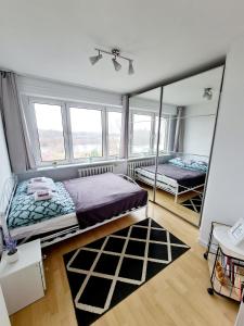 a bedroom with two beds and a mirror at Apartament LAKE z widokiem na jezioro in Ostróda