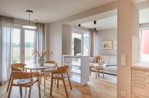 a dining room and living room with a table and chairs at Bades Huk Ferien-Resort in Hohenkirchen