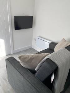 a living room with a couch and a flat screen tv at Carriage Lodge - Stunning Apartment with parking in Wateringbury