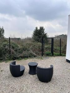 three black chairs and a table in front of a fence at Carriage Lodge - Stunning Apartment with parking in Wateringbury