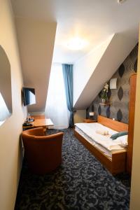 a hotel room with a bed and a chair at Centrum Promocji Zdrowia Sanvit in Sanok