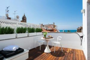 balkon ze stołem i 2 krzesłami oraz oceanem w obiekcie Kare No Apartments by Sitges Group w mieście Sitges