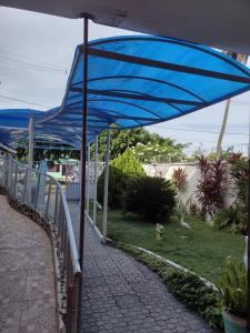 勒西菲的住宿－Casa em Ponta De Pedras- Encanto do Litoral!，蓝伞,坐在步行道上