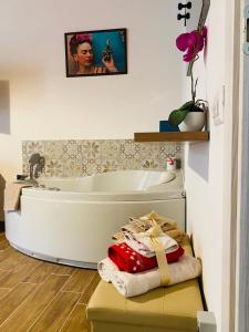 La salle de bains est pourvue d'une baignoire blanche et d'un lavabo. dans l'établissement FRIDA GUEST HOUSE, à Iglesias