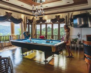 安塞罗亚莱Ocean Terrace的站在一个房间里台球桌旁的女人