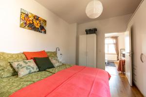 ein Schlafzimmer mit einem Bett mit einer roten Decke in der Unterkunft Ferienwohnung Jenzigblick in Jena